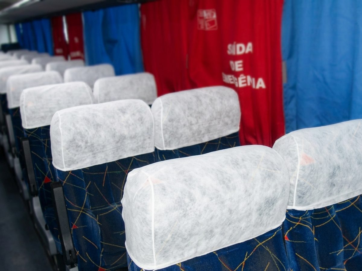 Cabeceiras em TNT branco cobrindo o encosto das poltronas
