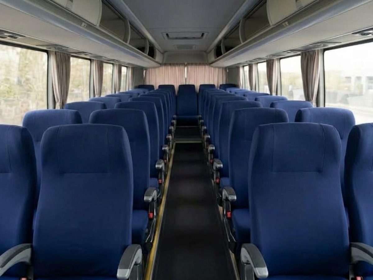 Fileiras de poltronas de ônibus com capa de banco azul-marinho