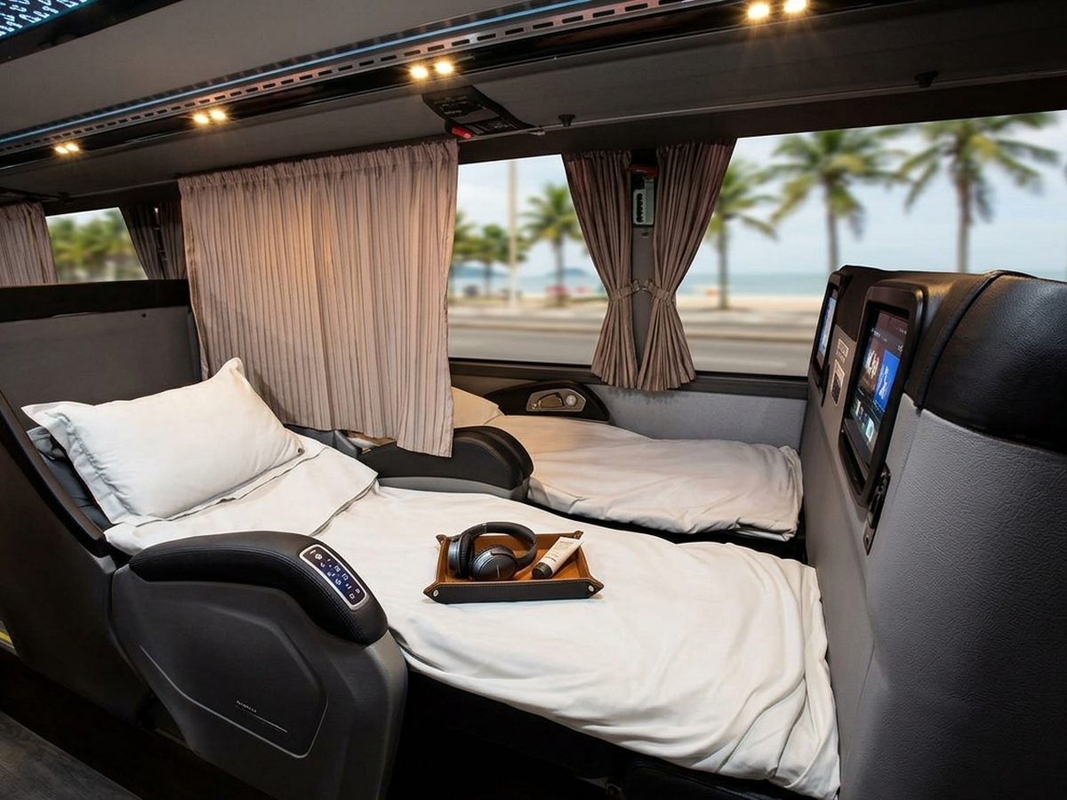 Poltrona-cama com lençol e travesseiro brancos em ônibus leito